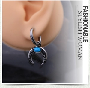 Détail de la boucle d'oreille croissant de lune avec turquoise et motifs celtes