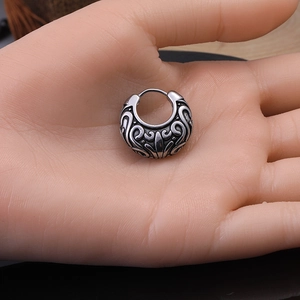 Vintage stainless steel hoop earrings with embossed scroll texture on hand model