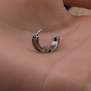 Mens stainless steel hoop earrings with dragon totem texture shown in hand for scale