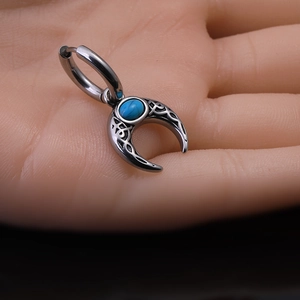Vue macro de la boucle d'oreille vintage en argent avec croissant de lune turquoise