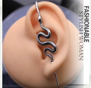 Detailed close-up of a silver snake ear cuff with intricate scale texture and punk design