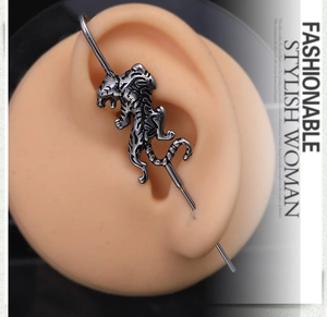 Macro view of vintage silver tiger ear cuff with punk style on a silicone ear model