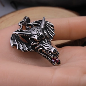 Retro stainless steel dragon head pendant with red gemstone eyes and detailed wings