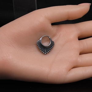 Détail d'un piercing de septum vintage en acier inoxydable oxydé sur main d'exposition