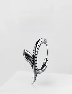 Macro shot of retro steel snake hoop earring featuring detailed scales and gothic textures