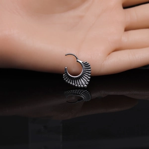 Détail macro d'un anneau de septum noir tribal avec texture nervurée et bord perlé