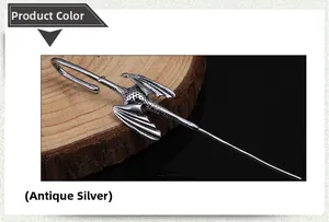 Close-up of antique silver dragon hair pin on wood slice with textured vintage details