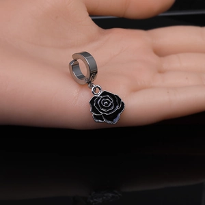 Détail d'un clip d'oreille rose en émail noir 3D sur un support en métal argenté poli
