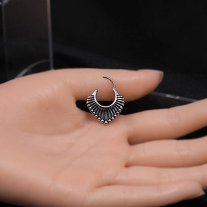 Vue macro de boucles d'oreilles en acier inoxydable argenté avec détails ciselés
