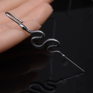 Detailed macro view of snake-shaped punk ear cuff with textured scale metal finish