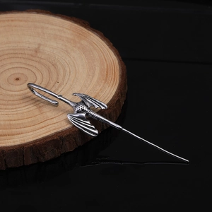 Vintage silver dragon hair pin with detailed wings on wood slice and black background