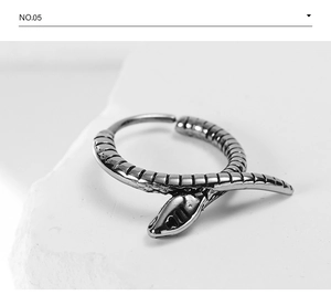 Detailed macro view of vintage snake-shaped titanium hoop earring with scale patterns