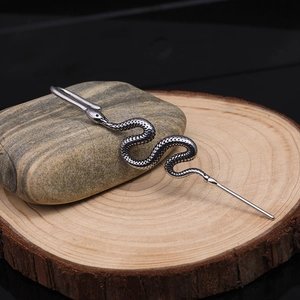 Detailed close-up of a snake-shaped vintage silver ear cuff with scale texture