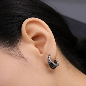 Detail of minimalist silver multi-layer hoop earring featuring parallel textured grooves