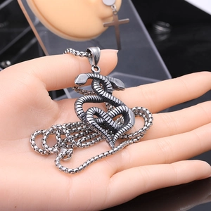 Gros plan du collier en acier vintage avec deux serpents entrelacés en forme de cœur