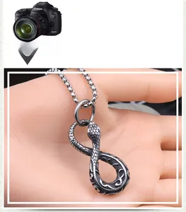 Macro shot of silver snake-shaped infinity pendant with detailed scale texture and carving