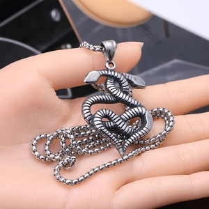 Détail macro du pendentif serpent argenté vintage avec texture d'écailles sur chaîne