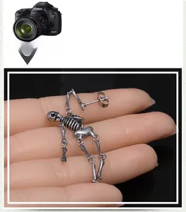 Detailansicht der Vintage Silber Skelett Totenkopf Ohrringe am realistischen Fingermodell