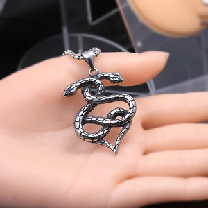 Détail du pendentif double serpent rétro avec écailles gravées sur une chaîne à billes