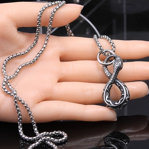 Retro punk snake pendant necklace in vintage silver steel finish on a display hand