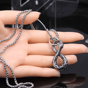 Detailed view of silver snake pendant with scale texture on a thick stainless steel chain