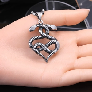 Détail du pendentif cœur serpent vintage en acier titane sur chaîne à billes en métal