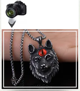 Détail du pendentif loup rétro en acier inoxydable avec œil rouge et textures précises