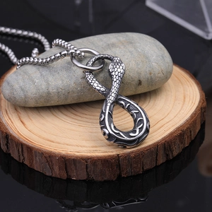 Macro detail of retro stainless steel snake pendant with textured scales on a metal chain
