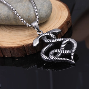 Vue détaillée d'un pendentif cœur double serpent en acier inoxydable sur une chaîne box
