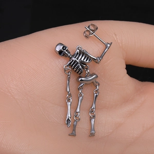 Makro-Detail des gotischen Totenkopf-Ohrrings mit beweglichen Gliedern aus Edelstahl