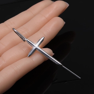 Boucle d'oreille croix en acier inoxydable argenté avec tige longue sur fond sombre