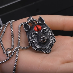 Gros plan du pendentif loup gothique en acier vintage avec détail d'œil d'animal rouge