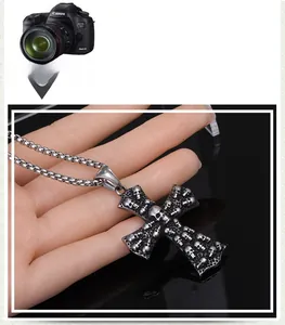 Vue détaillée du pendentif croix punk vintage avec reliefs de crânes complexes