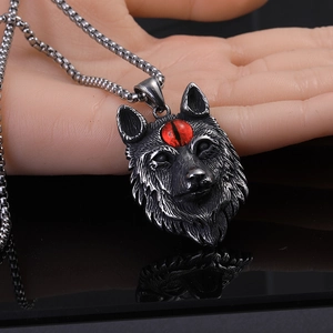 Détail du pendentif tête de loup vintage avec pierre rouge et chaîne en métal épais