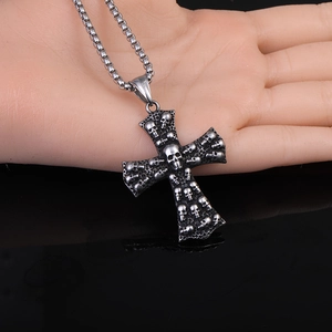 Gros plan du pendentif croix crâne punk vintage avec gravures gothiques sur chaîne box
