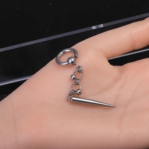 Detailed macro view of punk stainless steel hoop earring with chain and spike cone pendant