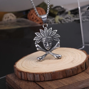 Pendentif vintage de crâne de chef indien en acier sur un fond de bois naturel