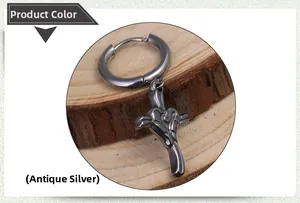 Detailed macro view of antique silver cross earring with heart relief on wood base