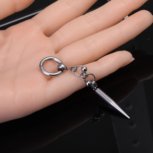 Close-up of punk style stainless steel hoop earring with long spike pendant held by hand