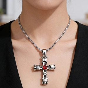 Pendente croce gotica retrò in argento con gemma rossa vista sul collo di un modello