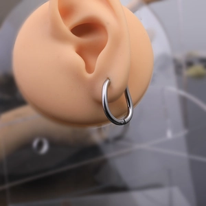 Silver teardrop Mobius hoop earrings in stainless steel on a realistic silicone ear model
