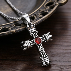 Dettaglio della collana vintage a croce argento con pietra rossa e motivi a corona