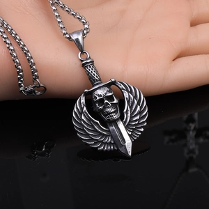 Detailed macro of punk winged skull and dagger pendant with vintage stainless steel finish