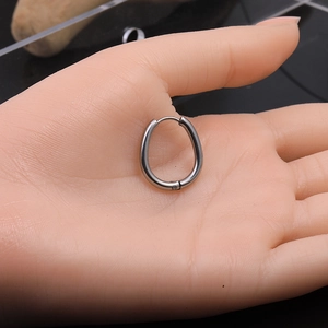 Close-up of geometric Mobius twisted hoop earrings held in hand with glossy finish
