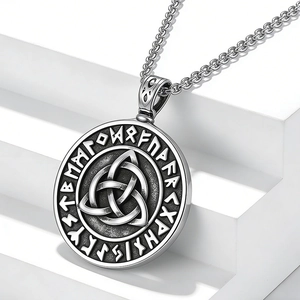 Détail macro du pendentif Triquetra nordique avec runes vikings en argent antique