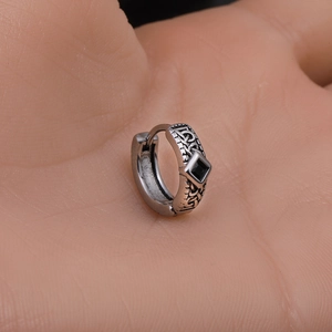 Macro shot of a vintage Celtic knot stainless steel earring with a square black zircon stone