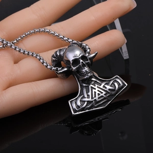 Gros plan d'un pendentif crâne viking argenté avec cornes de bélier sur chaîne en métal