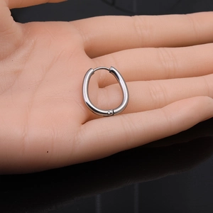 Detail shot of silver Moebius hoop earring on hand showing polished steel finish
