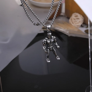 Détail macro d'un pendentif bodybuilder en acier inoxydable avec une finition vintage mate