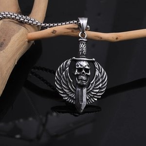Macro detail of gothic skull and sword pendant on a stainless steel punk necklace